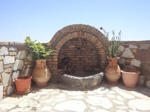 a brick oven with potted plants in front of it at Panorama Studios in Kefalos