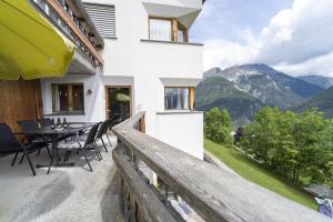 a balcony with a table and chairs and mountains at Chasa Tanter Vias - Capricorn in Scuol