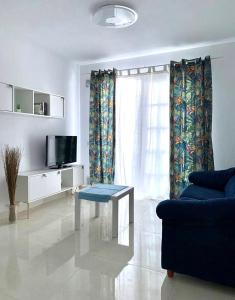 sala de estar con sofá, TV y mesa en Beautiful 1bd apartment in Los Cristianos, en Adeje