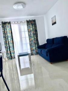 a living room with a blue couch and a table at Beautiful 1bd apartment in Los Cristianos in Adeje