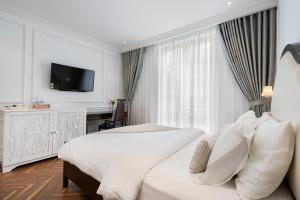 a hotel room with a bed and a television at Diamond Boutique Hotel in Ho Chi Minh City