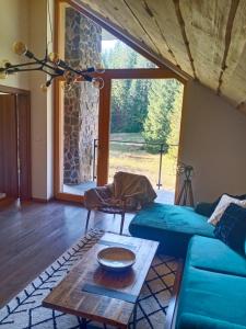 a living room with a blue couch and a table at Villa Erdődy Resort in Oravská Lesná