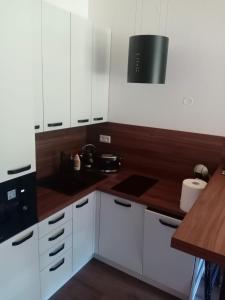 a kitchen with white cabinets and a wooden counter top at Villa Erdődy Resort in Oravská Lesná