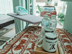 Inap Idaman 5 With 2 Queen Bed In Kubang Kerian في Kota Bharu: طاولة مع زجاجتين من المياه على شرفة