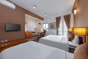 a hotel room with two beds and a television at Hanoi Golden Sunshine Villa Hotel and Travel in Hanoi