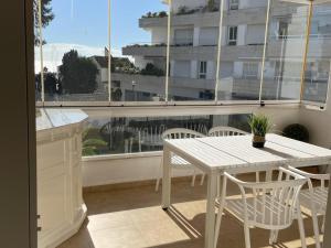una mesa blanca y sillas en un balcón con ventana en Homely Home Marbella Del Mar 5, en Marbella