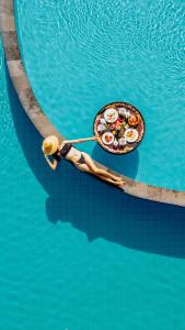 a person in a boat with food on it in the water at Uma Dawa Resort and Spa in Ubud