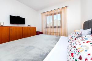 - une chambre avec un lit et une télévision à écran plat dans l'établissement Apartments Mirela, à Rovinj