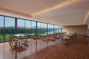桂林的住宿－桂林喜來登飯店，用餐室配有桌椅和大窗户