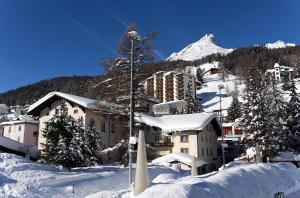 a resort in the snow with a mountain in the background at Hotel Parsenn in Davos