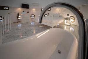 uma banheira num quarto com um quarto em Conjunto de APARTAMENTOS ANTIGUO PALACIO HOTEL PARIS em Huelva