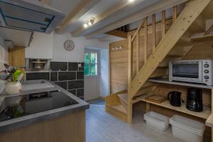 a kitchen with a wooden staircase with a microwave at Chalet KOCH in Saint-Pierre-de-Chartreuse