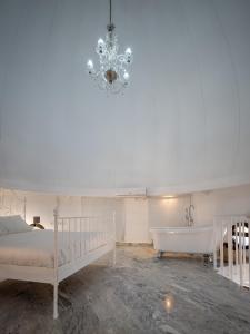 ウエルバにあるConjunto de APARTAMENTOS ANTIGUO PALACIO HOTEL PARISのベッドルーム1室(ベッド1台、バスタブ、シャンデリア付)