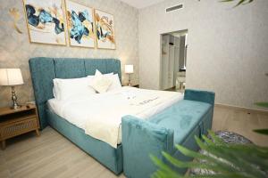 a bedroom with a bed with a blue couch at Yas Island 2 BR Turquoise in Abu Dhabi