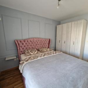 ポドゴリツァにあるStefanijaのベッドルーム1室(ピンクのヘッドボード付きの大型ベッド1台付)