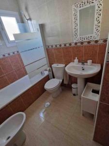 une salle de bain avec toilettes, lavabo et miroir dans l'établissement Villa Rose, à Camposol