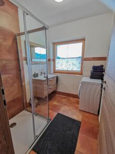baño con ducha, lavabo y ventana en Ferienwohnung Kramerhof, en Ebbs