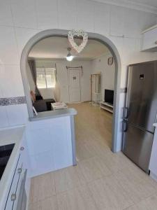 a kitchen with an archway and a living room at Villa Rose in Camposol
