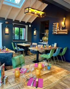 un comedor con mesas y sillas verdes en Logis Hôtel et Chalets Les Chatelminés, en La Bresse