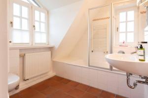un bagno bianco con lavandino e vasca di LH Isernhagenhof, App 3 a Wenningstedt