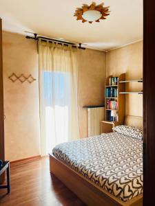 a bedroom with a bed and a book shelf at Orio Relax&Fly in Grassobbio