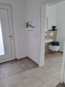 biała łazienka z toaletą i umywalką w obiekcie Große Pause - Moderne Ferienwohnung nahe Steinhude w mieście Hagenburg