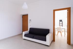 - un canapé noir et blanc dans une chambre avec une table dans l'établissement Casa Noiana by Wonderful Italy, à Noicàttaro