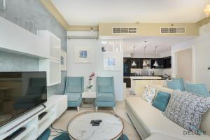 a living room with a white couch and blue chairs at Calm 3BR in The Signature Downtown by Deluxe Holiday Homes in Dubai