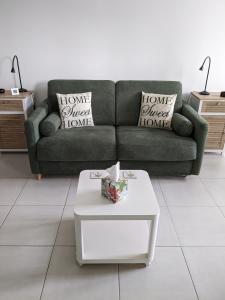 sala de estar con sofá y mesa de centro blanca en Les Jolis Nids - Studio Moineau, en La Roche-Posay