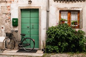 ein Fahrrad, das vor einer grünen Tür parkt in der Unterkunft Buonocore Guesthouse in Bergamo