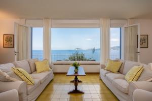 un soggiorno con divano e una grande finestra di Villa Escalina with private beach and A/C a Marciana Marina