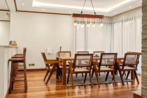 a dining room with a wooden table and chairs at Kirimara Woodlands, Nanyuki in Nanyuki