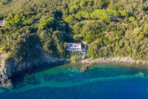 an aerial view of a house on a hill next to the ocean at Villa Escalina with private beach and A/C in Marciana Marina