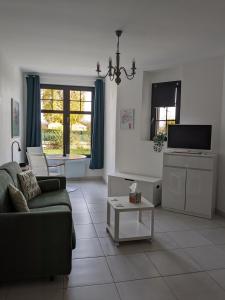 a living room with a couch and a tv at Les Jolis Nids - Studio Moineau in La Roche-Posay