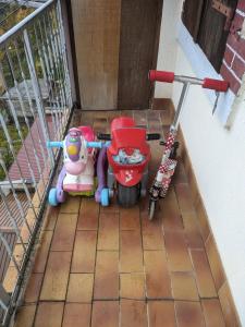 een balkon met 2 kinderstoelen en een scooter bij Appartement et salle de jeu in Saint-Claude