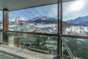 a view from the balcony of a resort with snow covered mountains at Hotel Gran Roc in Sestriere