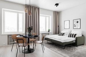 a bedroom with a bed and a table and chairs at Prime Apartments Pori Central in Pori