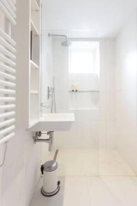 uma casa de banho branca com um lavatório e um espelho em Peaceful and Quiet 1BR Cottage in Camberwell em Londres