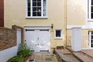 uma casa branca com uma porta branca e um edifício em Peaceful and Quiet 1BR Cottage in Camberwell em Londres
