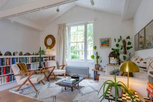 uma sala de estar com paredes brancas e uma grande janela em Peaceful and Quiet 1BR Cottage in Camberwell em Londres