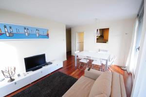 sala de estar con sofá, TV y mesa en Apartamento mirador del valle wowrural, en Sabiñánigo