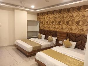 a hotel room with two beds and a wall at Hotel Lake View AC room in Vadodara
