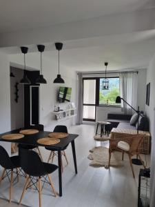 a living room with tables and chairs and a couch at HCT Sinaia Apartment in Sinaia