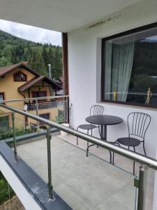 a balcony with two chairs and a table on it at HCT Sinaia Apartment in Sinaia +16 photos