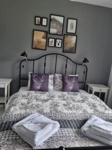 a bedroom with a bed with purple pillows and pictures on the wall at HCT Sinaia Apartment in Sinaia