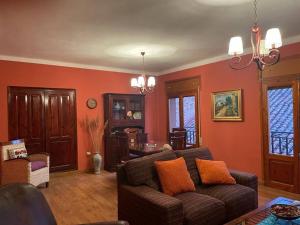 salon z czerwonymi ścianami i kanapą w obiekcie El refugio de Izan w mieście Mora de Rubielos