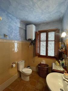 łazienka z toaletą i umywalką w obiekcie El refugio de Izan w mieście Mora de Rubielos