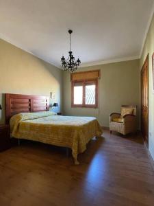 1 dormitorio con cama, ventana y silla en El refugio de Izan, en Mora de Rubielos