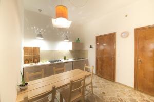 una cucina con tavolo in legno e una sala da pranzo di Camera A Sud a Mazara del Vallo