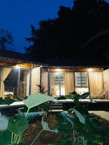 una casa con plantas delante de ella por la noche en Anh Duc Homestay, en Sa Pa